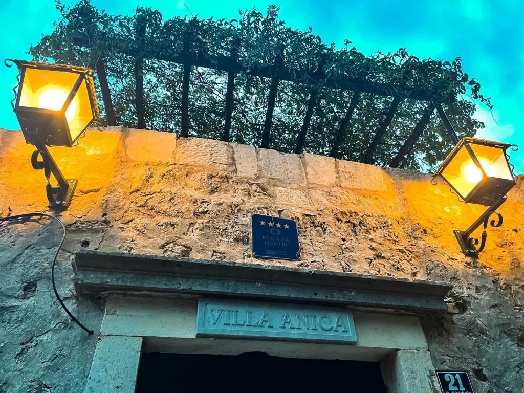 Stone entrance of Villa Anica Dubrovnik with lanterns and the name above the door